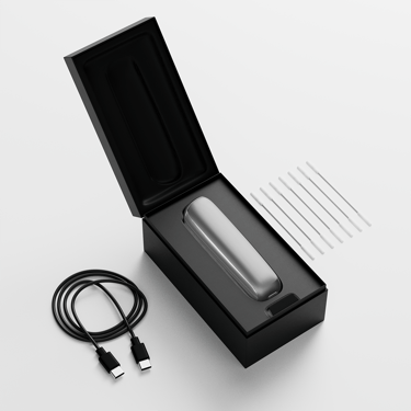 Ploom AURA otvorena kutija koja prikazuje uređaj, kabl za punjenje i štapiće za čišćenje. 
