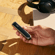 Ploom AURA device with Jet Black front panel held in hand.