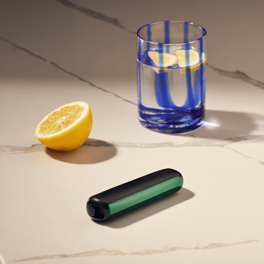 Aksesoar Ploom AURA Amazon Green prednja maska pričvršćena za uređaj je na stolu
