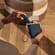 User taking a Ploom AURA device out of the Denim Leather Fusion Solo Carry Case.