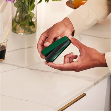 Ruka postavlja Amazon Green zadnju masku na Ploom AURA uređaj
