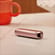 Close-up of a Ploom AURA front panel Rose Gold accessory on a flat surface.