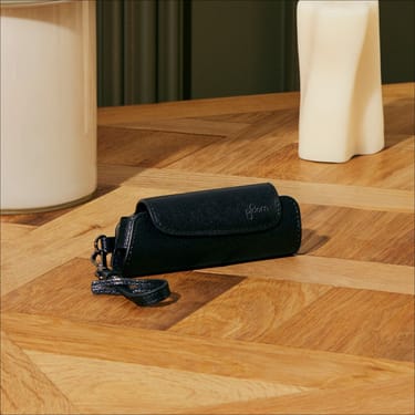 Aksesoar Ploom AURA Jet Black solo torbica na stolu
