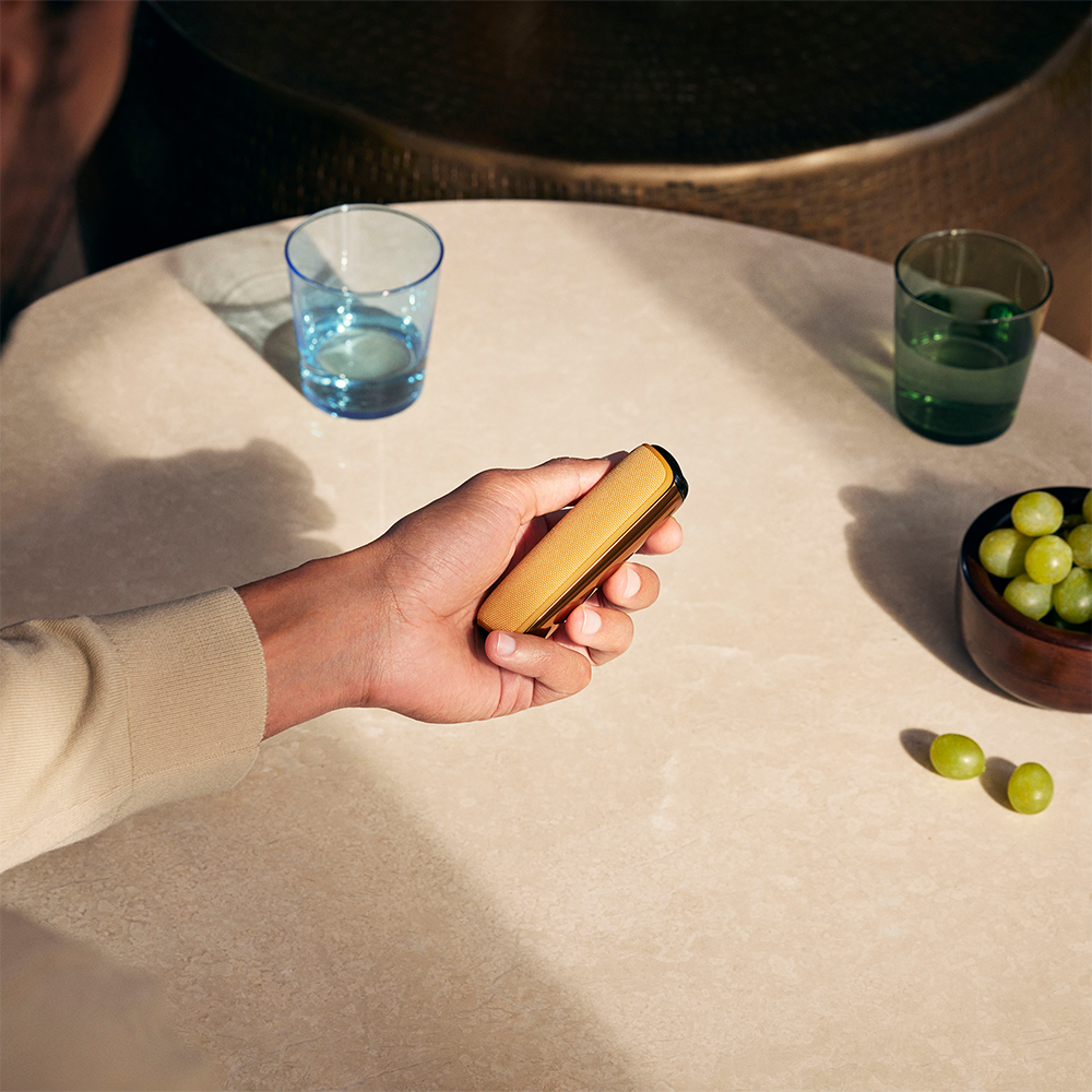 "Ruka pokazuje na Ploom AURA Mango Sorbet zadnju masku koja je pričvršćena za uređaj. 
"
